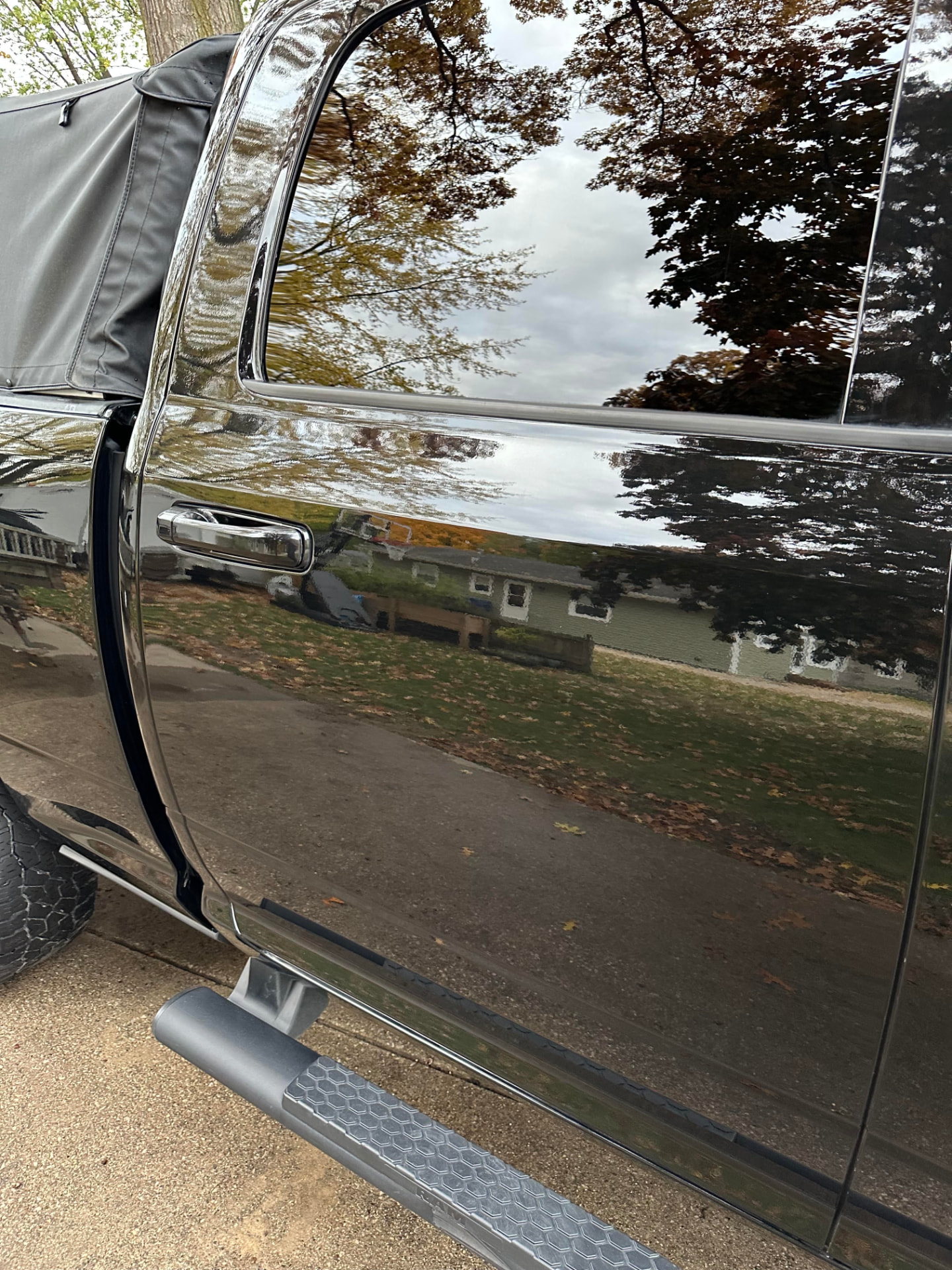 Glossy black truck panel after an exterior detail by Lake Michigan Superior Detail.
